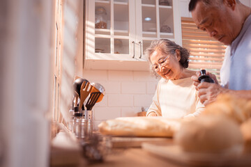 Happy Asian grandparents enjoying cooking the mealtime in the kitchen