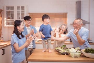 Happy Asian family preparing food together in a bright kitchen,
