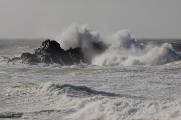 Breaking waves over sea rocks