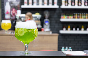 Creative green cocktail with cucumber slices served at modern bar