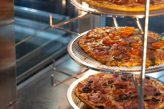 Delicious pizza varieties on display at a bustling eatery in the evening