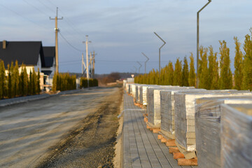 Suburban street under construction with paving materials and landscape design