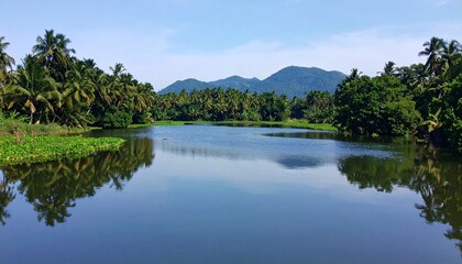 tranquil kerala backwaters mirroring lush tropical vegetation and majestic mountains under a serene sky