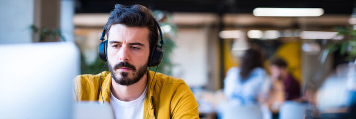 neurodiverse programmer working with noise-cancelling headphones and focused interface