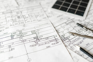 sustainable architecture tools and materials: blueprints, solar panel, wood textures, fabric swatches, and stones. Eco-friendly design, conscious construction and green innovation.