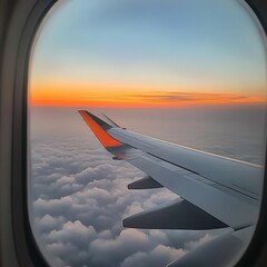 Obraz premium Aircraft Wing Over Clouds with Sunset Sky View from Plane Window Perspective Shot