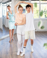 Positive girl and boy dancing slow ballroom dance in choreography studio