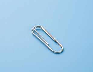 Close-up of a Shiny Silver Paperclip on a Blue Surface