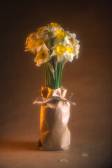 Beautiful bouquet of fresh daffodils wrapped in brown craft paper, tied with twine, creating a rustic and charming presentation on a table with soft, warm effect
