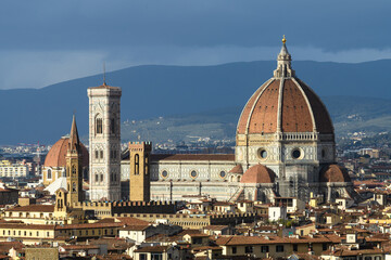 View of Florence Cathedral Santa Maria del Fiore with Brunelleschi's dome and Giotto's bell tower under dramatic evening light. Florence, Tuscany, Italy.