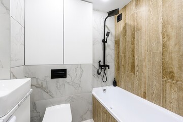 Modern bathroom with white marble tiles, white fixtures, and matte black hardware for a chic, minimalist design