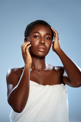 Fototapeta premium Woman poses elegantly with a towel in a studio setting during a beauty shoot focusing on skincare and natural beauty