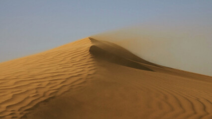 Sand blowing over sand dunes in wind