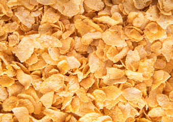 Original yellow healthy corn flakes breakfast cereal with vitamins textured macro shot.Top view.