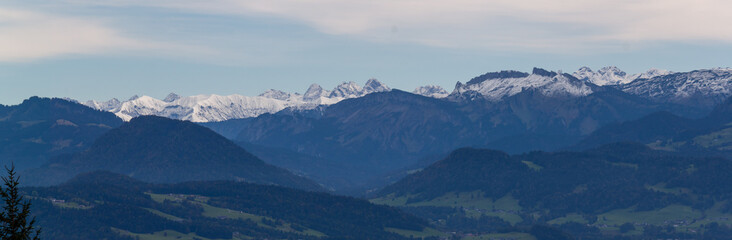 Breathtaking panoramic view from the Pfänder mountain in showcasing the majestic snow-capped Alps stretching across the horizon