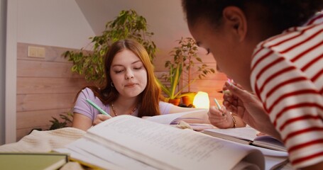 Teenage girls do their homework together. Working on a joint project