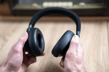 Wireless headphones in hand, listen to old Vintage 60s radio, happily while listening to music, podcast, Retro aesthetic