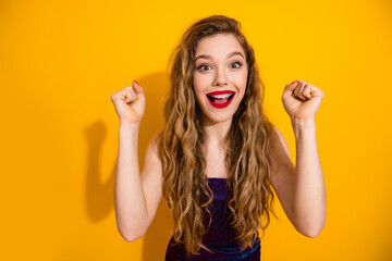 Excited young woman with long curly hair posing against a vibrant background expressing joy and...