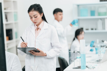 Young researchers collaborating in a modern laboratory, conducting chemical and biological...