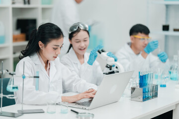 Young researchers collaborating in a modern laboratory, conducting chemical and biological...