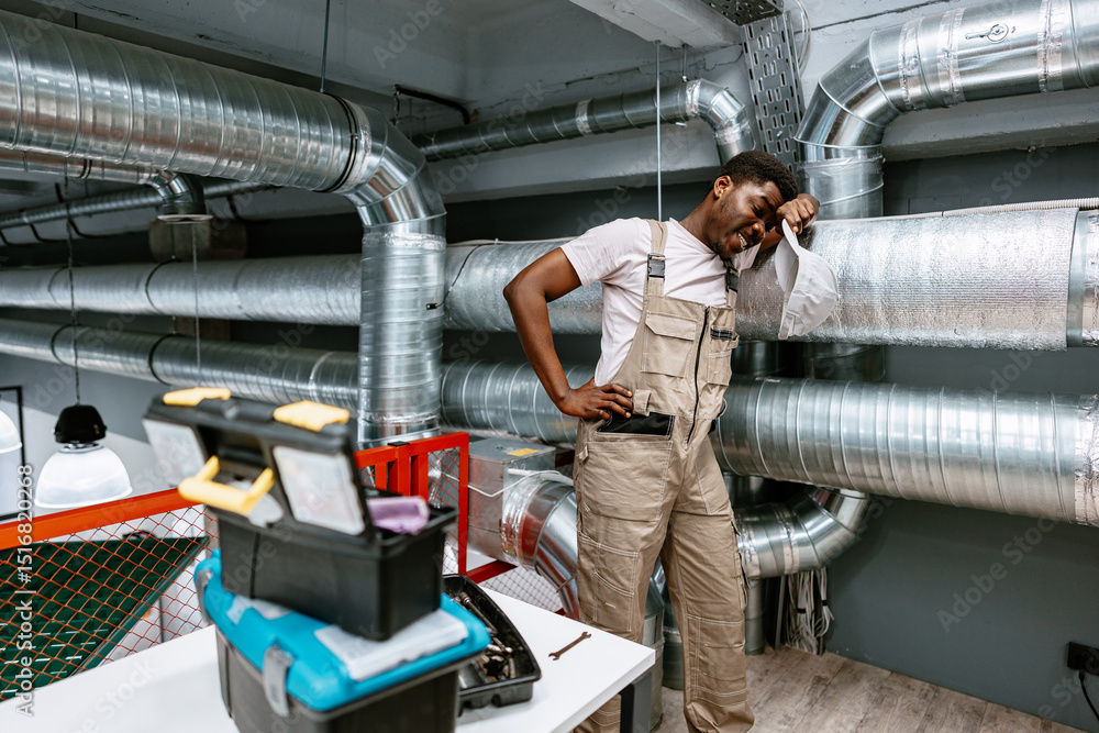 Poster worker assesses ventilation system in industrial space while troubleshooting issues during afternoon