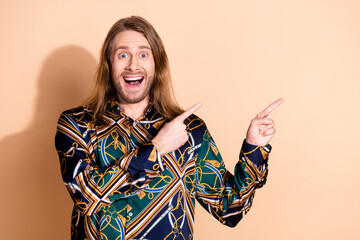 Charismatic young man gesturing enthusiastically on a beige background, expressing joy and...