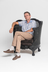 Senior sitting in an armchair and pensive, dreamy