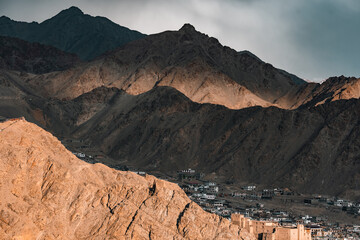 A scenic view of Leh town nestled in the rugged Himalayas, surrounded by dramatic brown mountains...