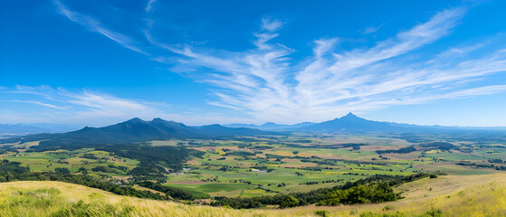 Obraz premium Panoramic View Of Valley With Green Fields And Hills Under A Clear Sky