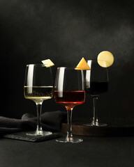 Elegant Wine Glasses with Cheese Garnish on Dark Background