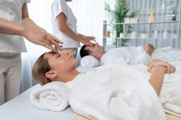 Caucasian couple enjoying relaxing anti-stress head massage and pampering facial beauty skin...