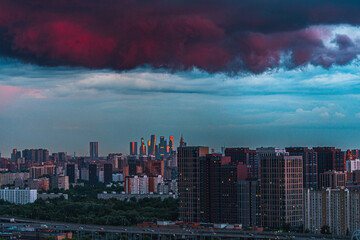 A storm cloud over a big city. Panorama of the city with multi-storey residential buildings before the rain, view from above
