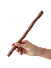 A woman's hand delicately holds a twisted brown dog treat stick against a plain white background, showcasing a healthy chew snack for canine dental care.