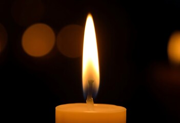 lit candle with a black background
