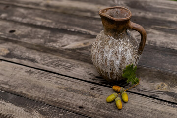 Still-life with jug and dry leaves of an oak
