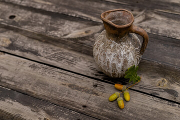 Still-life with jug and dry leaves of an oak