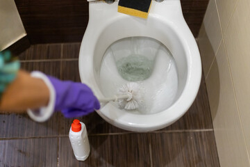 Cleaning the toilet.