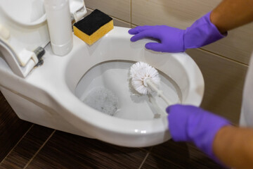 Cleaning the toilet.