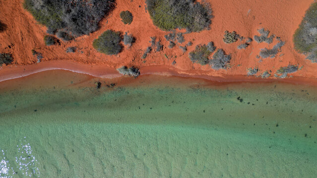A creek running through the red soil of Australia, Western Australia, seen from above