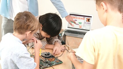 Group of diverse student working together on main board with laptop screen display engineering...