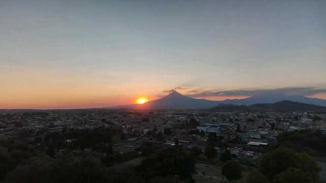 Sunset over the exploding Popocatpetl volcano, time lapse