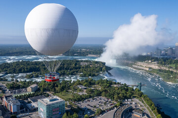 Niagara Falls, observation balloon, tethered balloon, aerial view, waterfall mist, tourist attraction, sightseeing balloon, adventure tourism, natural wonder, scenic overlook, bird's eye view, Canada.