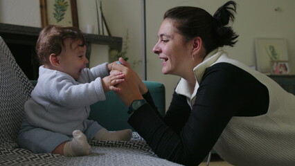 Mother holding object to engage baby, encouraging sensory exploration and focus, nurturing playtime...