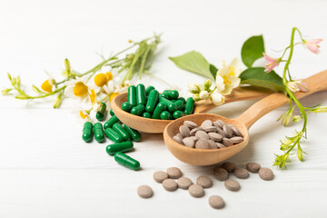 Alternative medicine herbal capsule organic drug on wooden background.Assortment of herbal and...