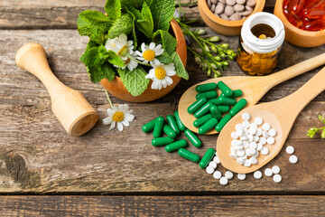 Alternative medicine herbal capsule organic drug on wooden background.Assortment of herbal and...