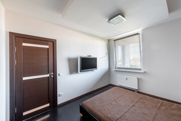 Modern Minimalist Home Bedroom Interior with Wooden Door and Wall-Mounted Television