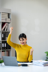 Excited Businesswoman Celebrating Success at Desk