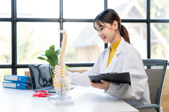 Female Doctor Examining Spinal Model