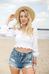 Portrait of beautiful woman wearing straw hat with large brim at beach