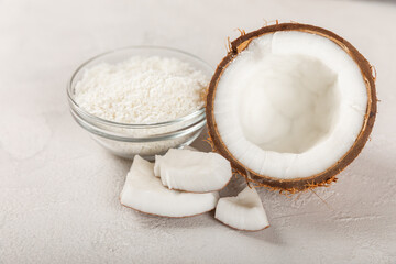 Set of fresh whole and half coconuts and slices on wooden background. Coconut flakes. Vegan. Tropical nut, fruit. Place for text. Copy space.